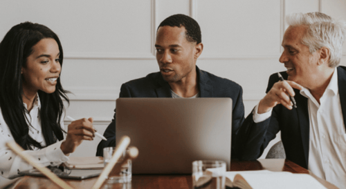 younger woman discussing paper with older man