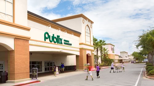 People sporadically walking through front outdoor area of Publix at Sun Plaza shopping center