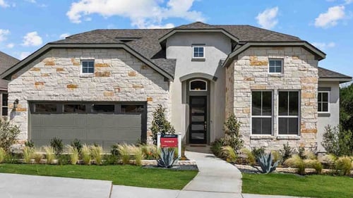 new home with brick exterior, tall windows, and double garage