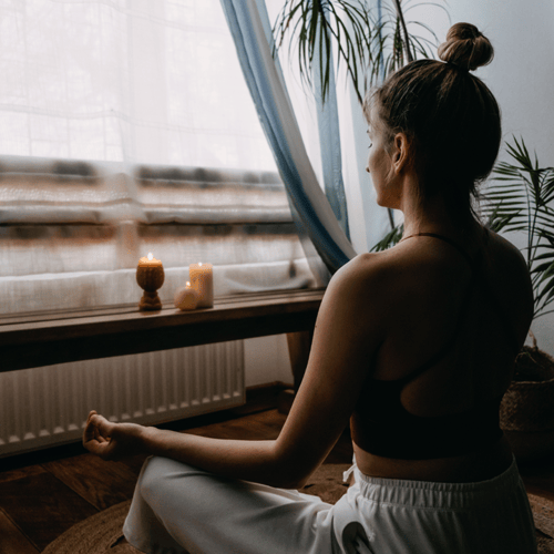 A woman is seen meditating in a calm environment