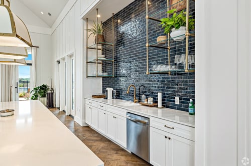 Modern clubhouse kitchen with blue tiles and white cabinets at Outpost Orchard in Foley, Alabama.