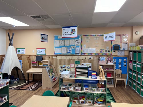 Bright and welcoming Pre-K classroom with colorful learning stations, sensory play, and creative activity spaces.