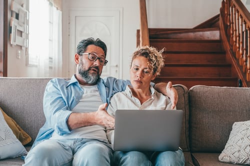 Confused couple looking at a laptop