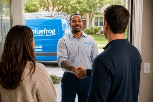 plumber at homeowners door shaking hands with van in background