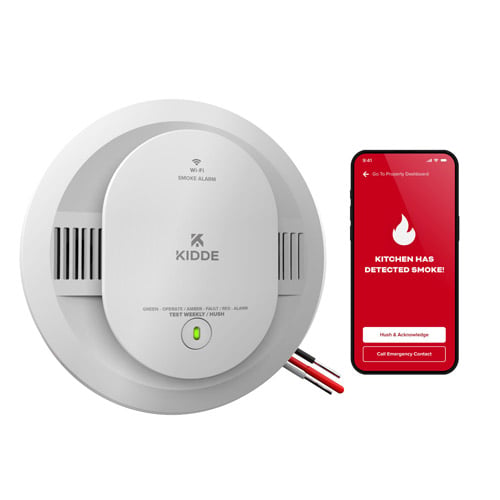 A smart smoke alarm next to a smart phone showing the Kidde app
