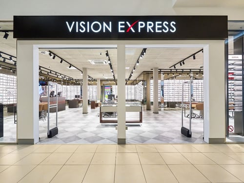 Vision Express üzlet bejárata, szemüvegpolcokkal és modern belső térrel.