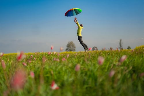 person holding umbrella trying to fly in air
