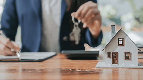 realtor behind a desk holding keys