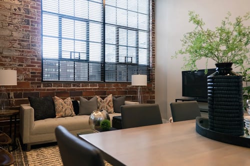 A living room with a brick wall and a wooden table at Station 121, Des Moines Iowa