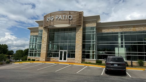 Exterior view of an RTG Patio store with stone columns and glass entrance.
