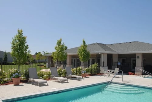 A swimming pool in front of a house at Castle Vista Senior Duplex Community in Atwater, CA 95301