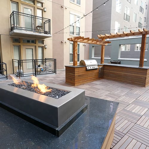 Garden courtyard at TwentyOne 01 on Market with BBQ grills, fireplace, and seating.