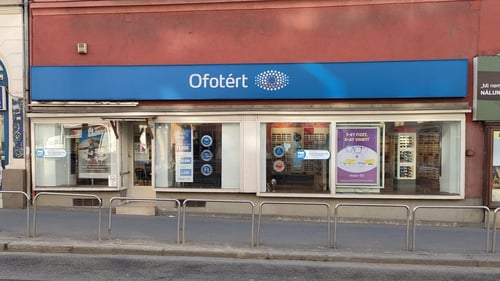 Ofotért üzlet bejárata Budapesten, a Margit körúton, nagy üvegportálokkal és szemüvegkeret‑kirakattal.