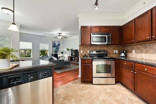 a kitchen with stainless steel appliances and wooden cabinets at Sovereign at Overland Park, Overland Park, KS 66213
