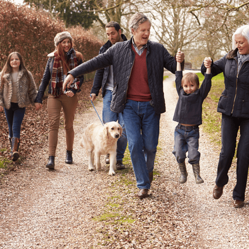 A family is seen walking together on a gravel path