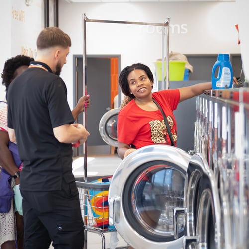 Speed Queen Laundry attendant assisting a customer at a washer