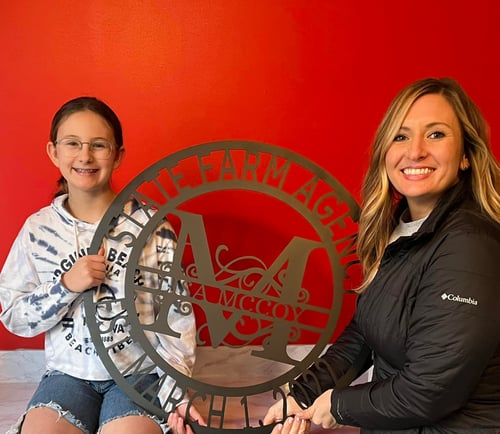 Agent Lisa and child smiling with State Farm sign