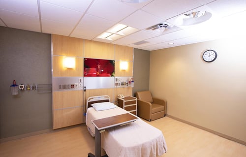 Another view of the labor and delivery room showing a bed and chair along with monitoring equipment