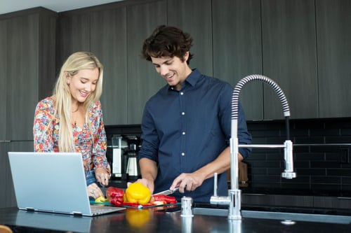 Couple in kitchen using Wi-Fi at home
