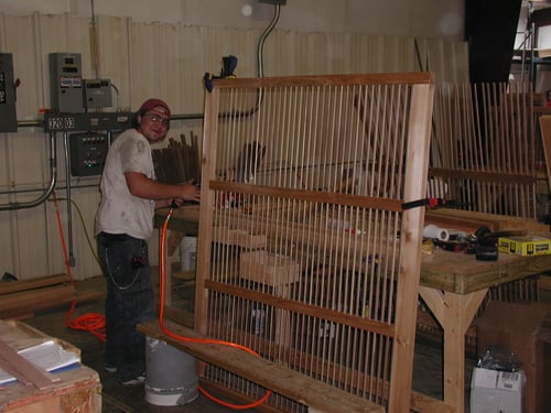Technician assembling custom exterior shutters in workshop