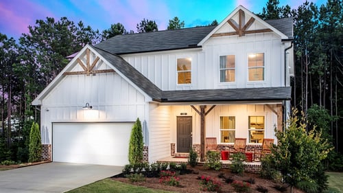two-story home with white siding and brick-accent porch