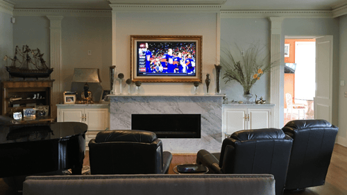 large living area with a TV above fireplace