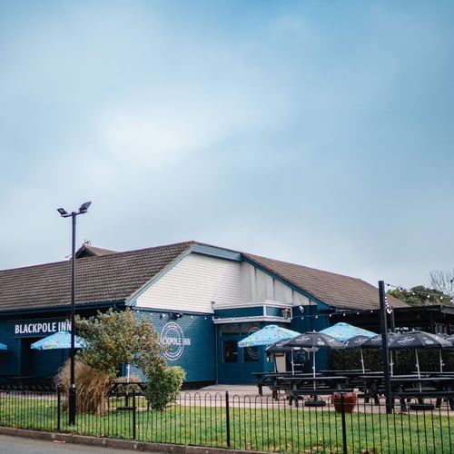 Exterior of Blackpole Inn with outdoor seating and signage