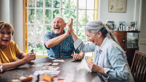 A group of seniors enjoying a friendly game of cards together, sharing laughter and good company.