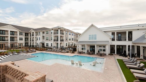 swimming pool with sundeck and apartment buildings
