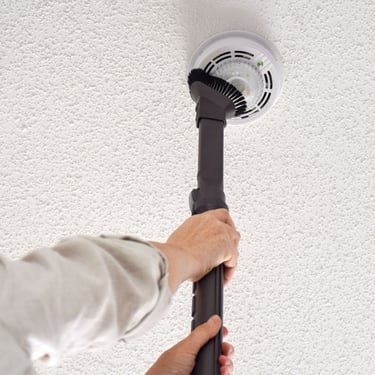 Image of a person vaccuming the strobe device