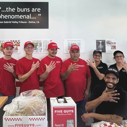 Crew members pose for a photograph ahead of the reopening of the Five Guys restaurant at 7110 Roger Avenue in Fort Smith Arkansas.