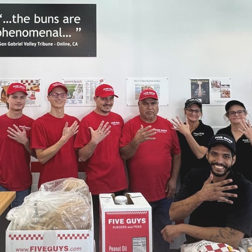 Crew members pose for a photograph ahead of the reopening of the Five Guys restaurant at 7110 Roger Avenue in Fort Smith Arkansas.