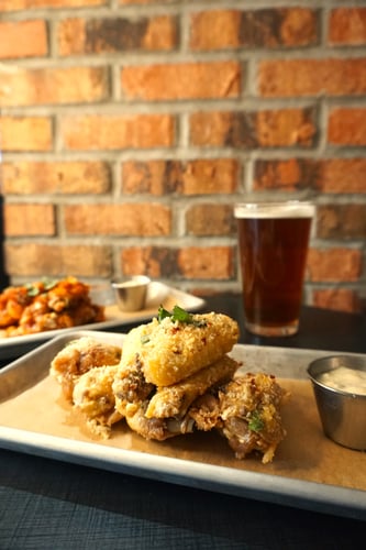 chicken wings next to a beer on tap
