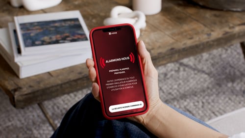Image d'une personne tenant un téléphone avec le nouveau simulateur de sécurité Kidde sur l'écran.