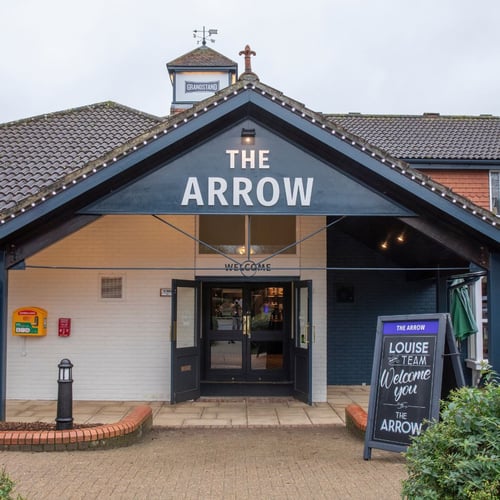 Front entrance of The Arrow pub with signage and covered doorway welcoming guests