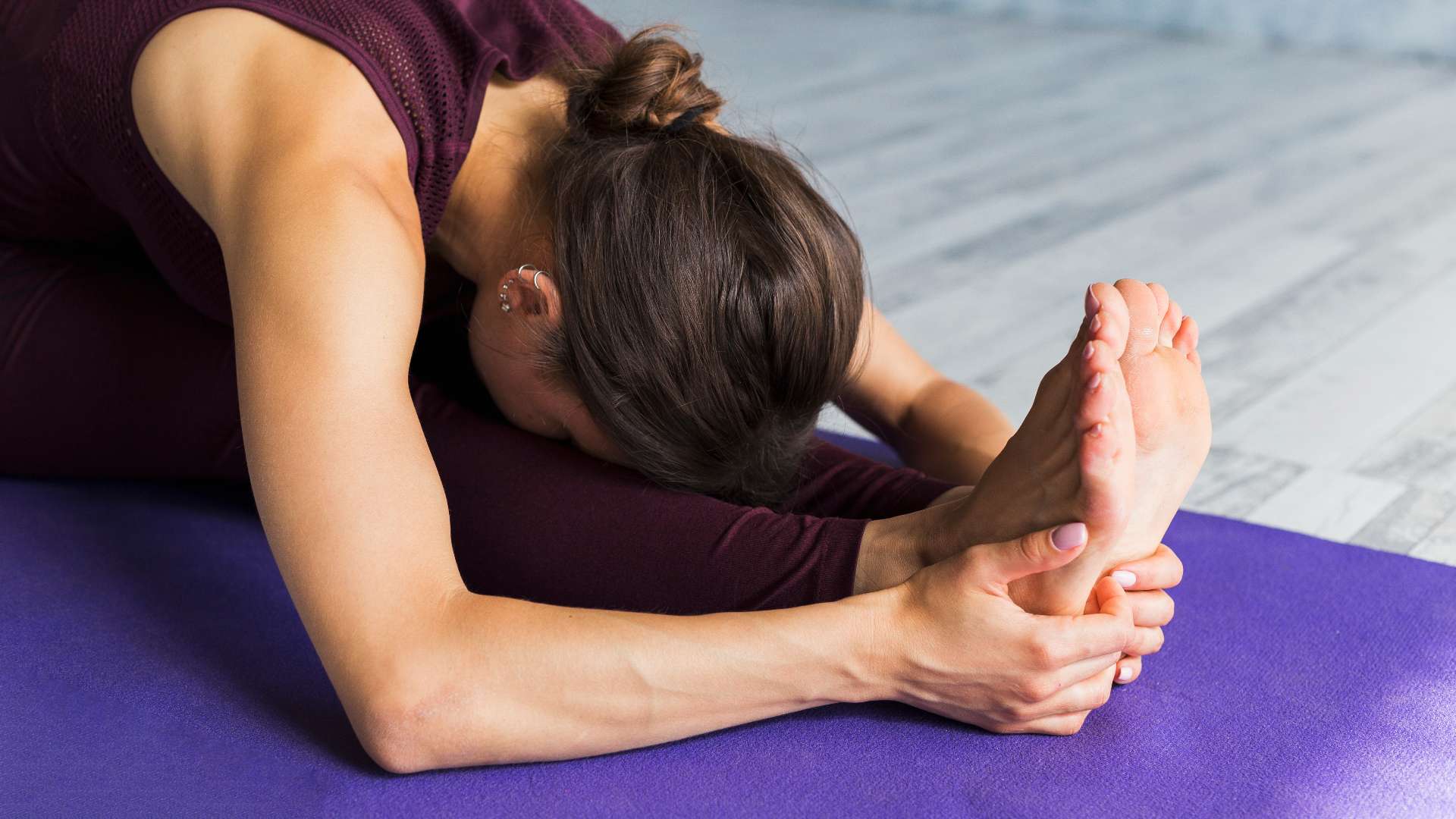 Person stretching while holding their feet