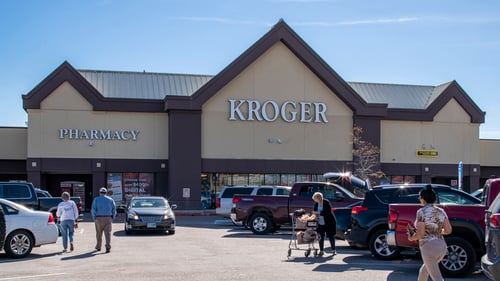 busy Kroger's parking lot of parked and driving cars and people walking with shopping carts at Texas City Bay shopping center