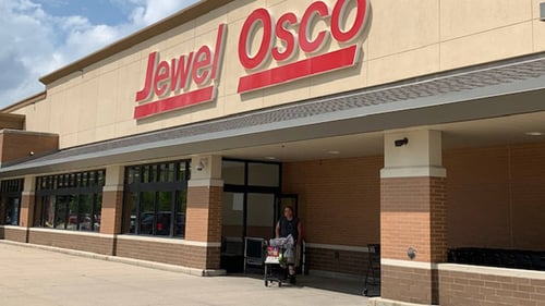 Man walking out of Jewel Osco with a shopping cart