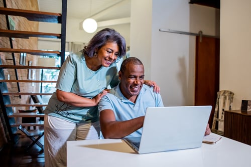 Couple smiling looking at computer