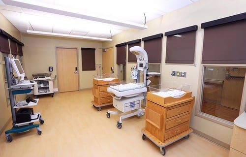 The nursery showing bassinets, an infant warmer and other equipment to care for infants.