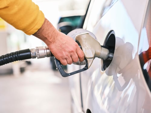 Individual filling up their car at a gas station.