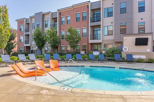 A resort style pool with orange chairs - Google Cover Photo