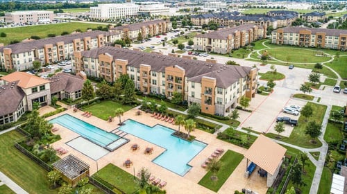 an aerial view of an apartment complex with a large swimming pool at Retreat at Shadow Creek Ranch Apartments, Woodburn, TX, 77584