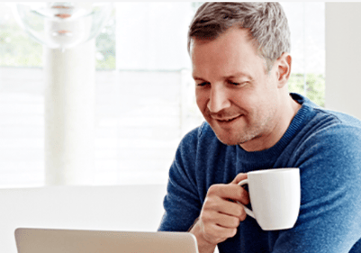 man drinking coffee and browsing on laptop