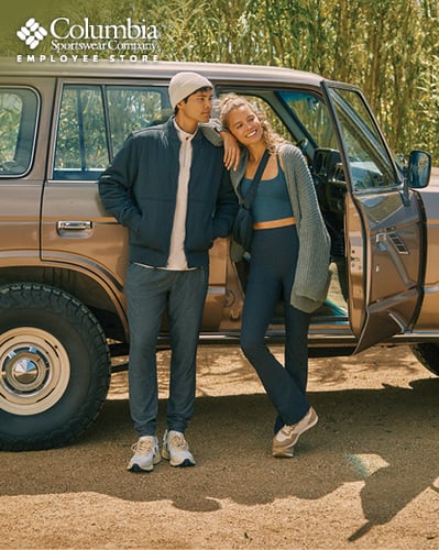 Two people standing in front of a car.