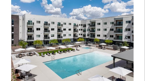 Resort style pool with sun deck and umbrellas at Lucero Apartments, Arizona, 85051