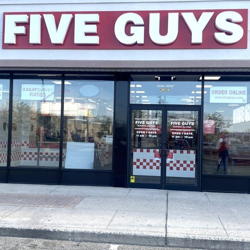 Exterior photograph of the entrance to the Five Guys restaurant at 70 Atlantic Avenue in Oceanside New York.
