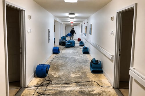 A Restoration 1 of Horry County technician places drying equipment in a hallway after a commercial water damage loss in North Myrtle Beach.