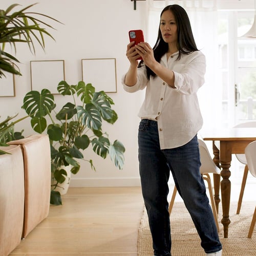 Woman standing using Kidde’s AR tool on phone