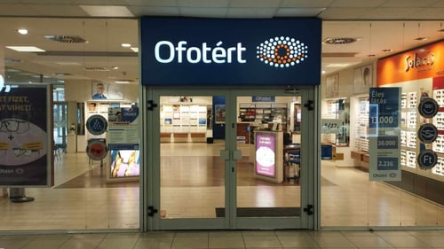 Ofotért üzlet bejárata Budapesten, a Flórián Üzletközpontban, üvegportállal és jól megvilágított belső térrel.